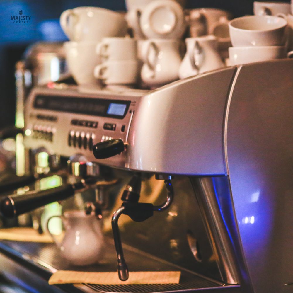 Commercial espresso machine with cups warming on top in a cafe